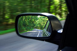 Landscape in the sideview mirror of a speeding car
